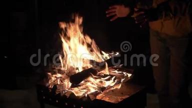 一个人在布拉齐尔附近用火取暖，在冬天他的手取暖。